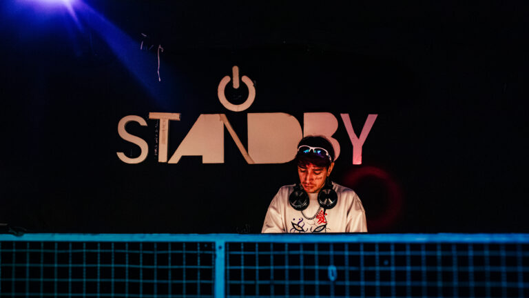 DJ na cabine sob o letreiro do Standby — Sad Baile Curitiba Halloween, 10/10/2026