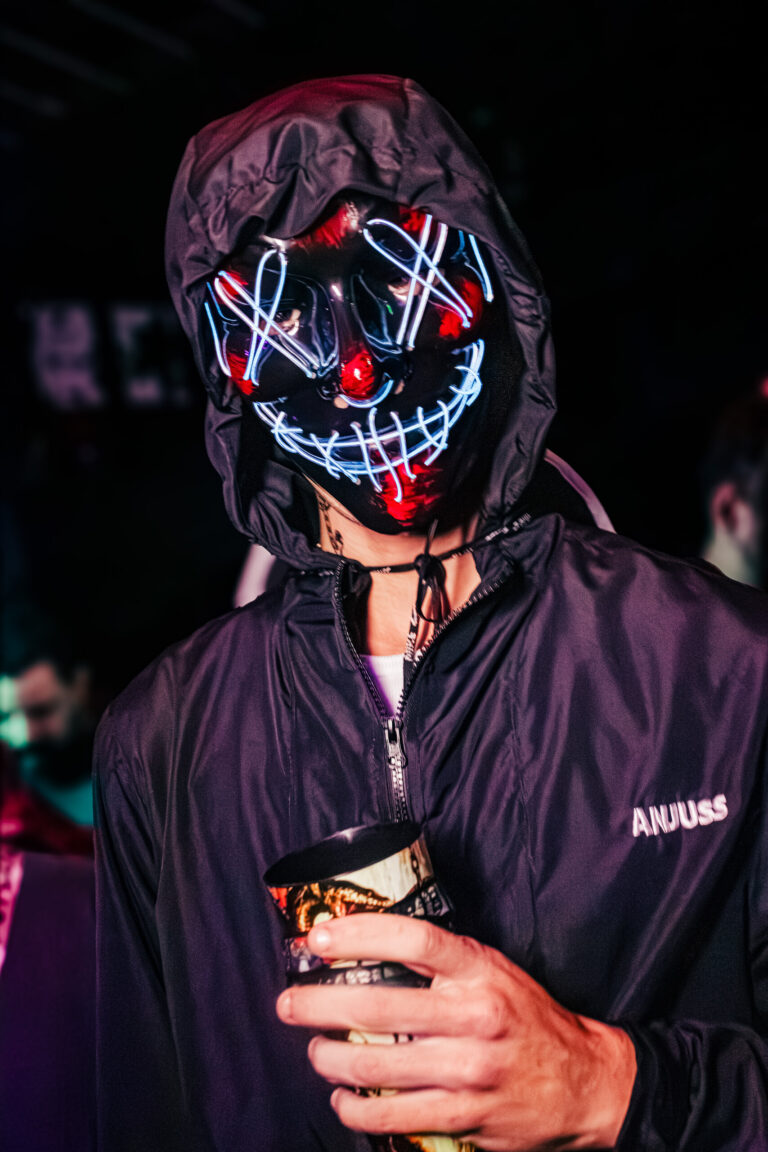 Pessoa com máscara de LED do filme Uma Noite de Crime — Sad Baile Curitiba Halloween, 10/10/2026
