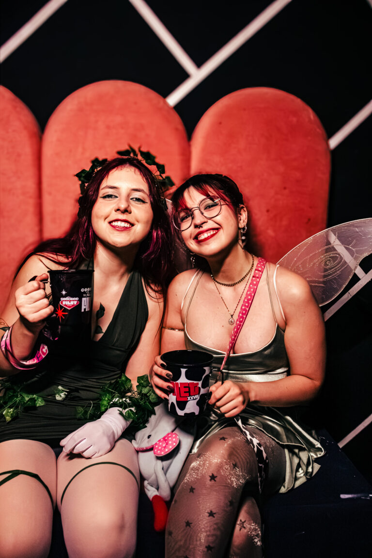Duas amigas fantasiadas de fada no sofá — Sad Baile Curitiba Halloween, 10/10/2026
