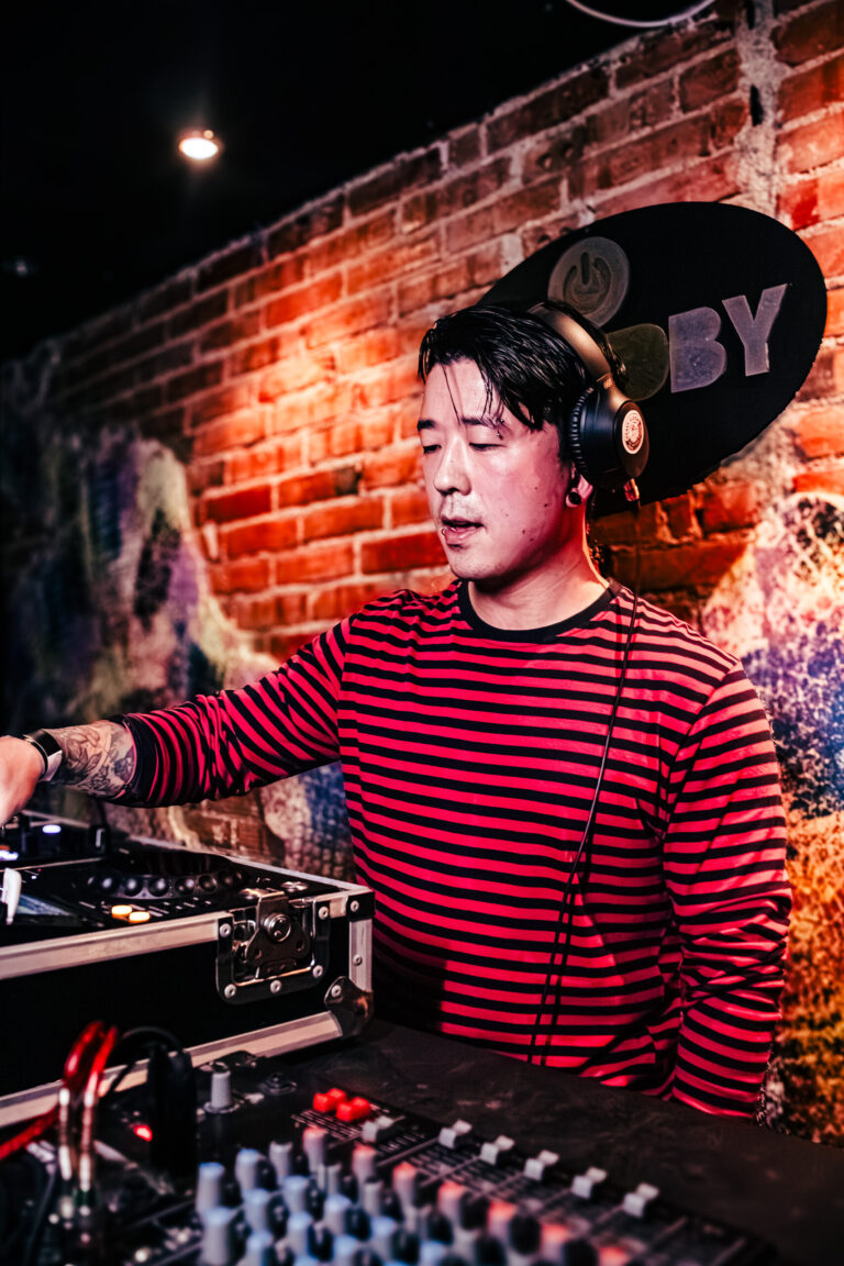 DJ de blusa listrada toca na cabine do Standby Music — Sad Baile Curitiba Halloween, 10/10/2026