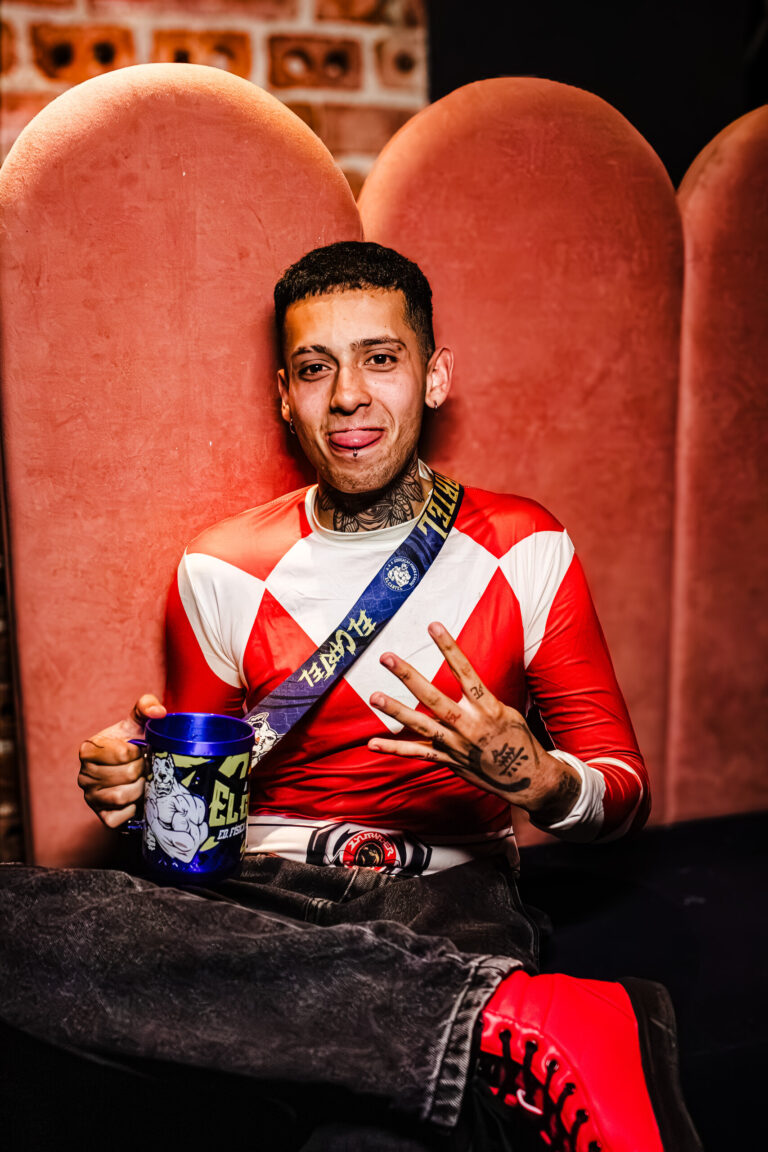 Rapaz fantasiado de Power Ranger vermelho no sofá — Sad Baile Curitiba Halloween, 10/10/2026
