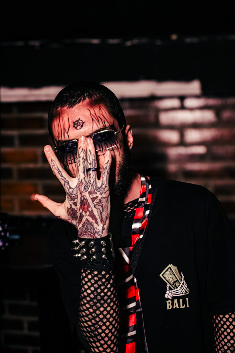 Rapaz com tatuagens no rosto faz sinal com a mão — Sad Baile Curitiba Halloween, 10/10/2026