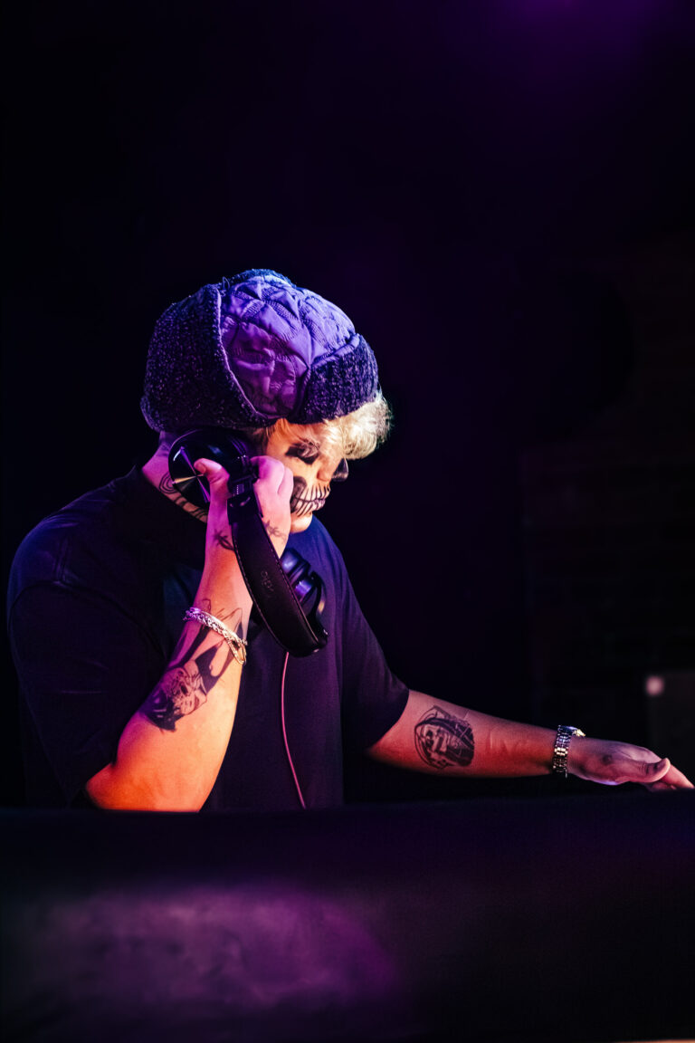 DJ com máscara roxa sob luz violeta — Sad Baile Curitiba Halloween, 10/10/2026