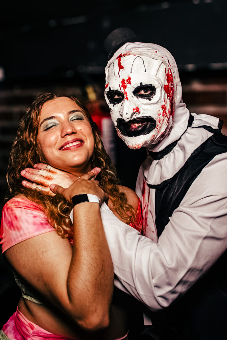 Garota abraçada com fantasia do palhaço Art, de Terrifier — Sad Baile Curitiba Halloween, 10/10/2026