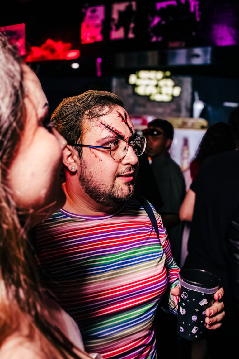 Rapaz fantasiado de Chucky com blusa listrada — Sad Baile Curitiba Halloween, 10/10/2026