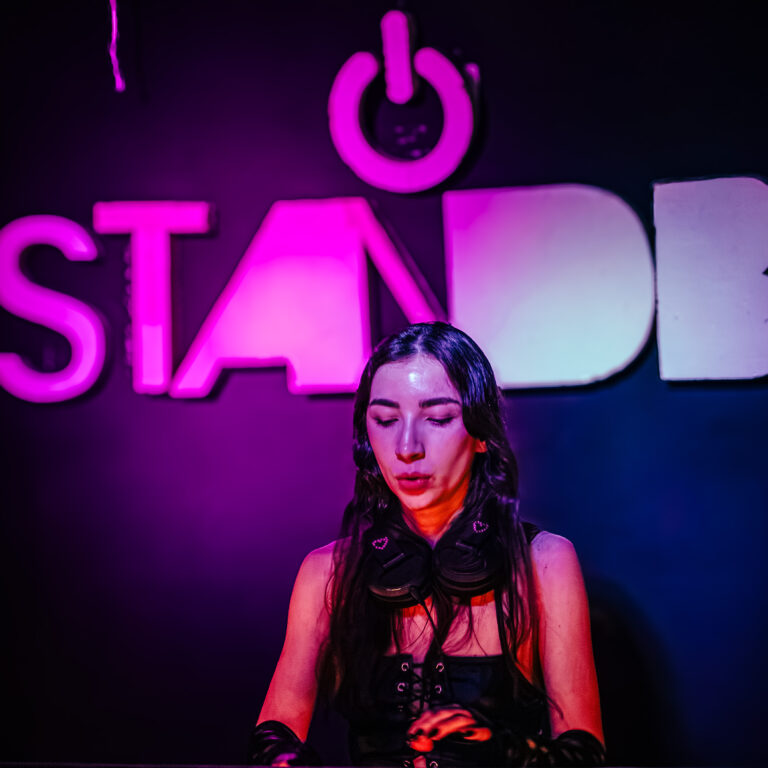 DJ toca sob o letreiro rosa do Standby — Sad Baile Curitiba Halloween, 10/10/2026