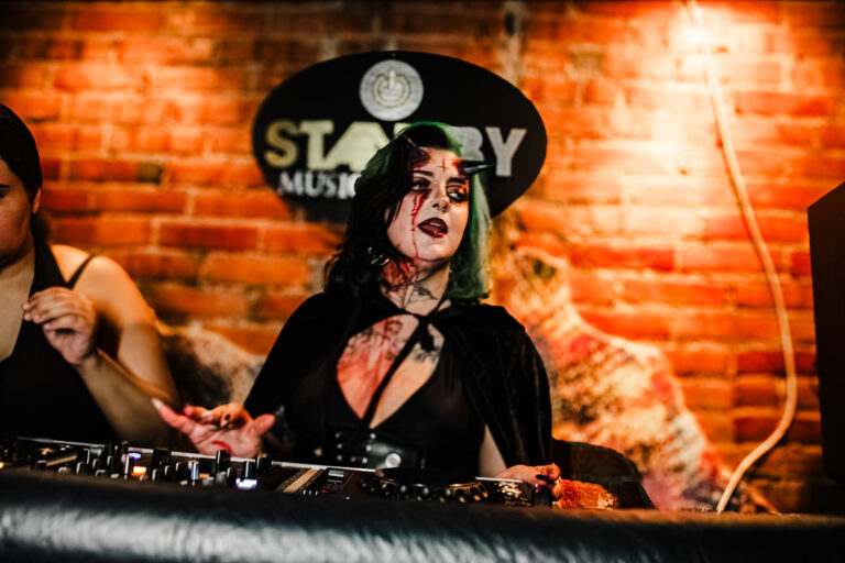 DJ de cabelo verde mixando no Standby Music — Sad Baile Curitiba Halloween, 10/10/2026