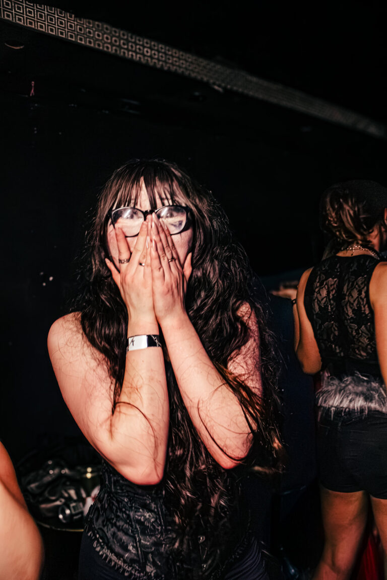 Garota cobre o rosto com as mãos na pista — Sad Baile Curitiba Halloween, 10/10/2026