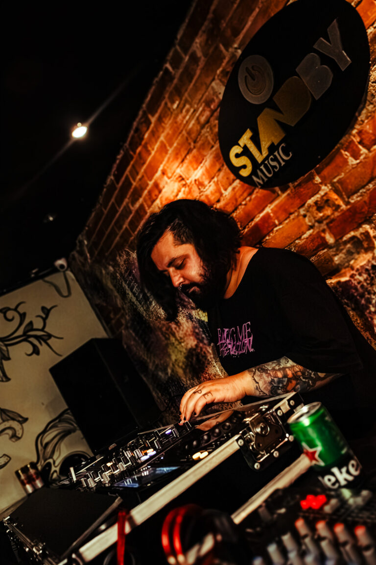 DJ toca em frente à parede de tijolos do Standby Music — Sad Baile Curitiba Halloween, 10/10/2026