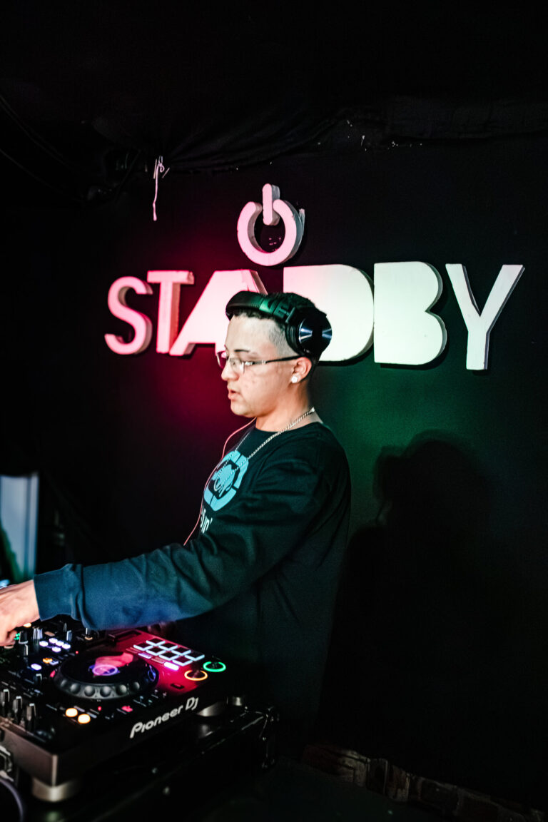 DJ toca sob o letreiro iluminado do Standby — Sad Baile Curitiba Halloween, 10/10/2026