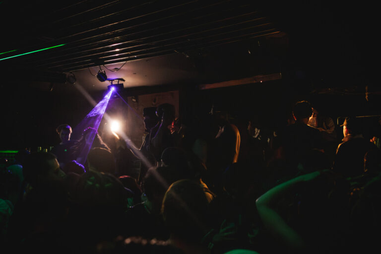Pista escura iluminada por canhões de luz — Sad Baile Curitiba Halloween, 10/10/2026