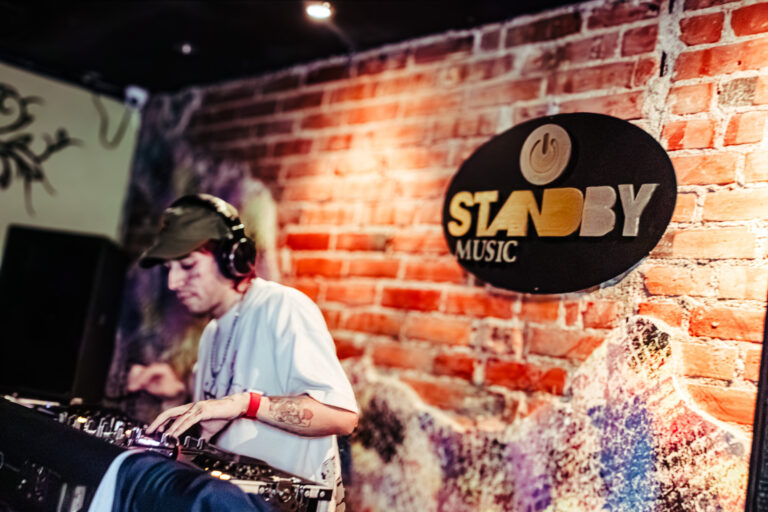 DJ mixando ao lado do logo do Standby Music — Sad Baile Curitiba Halloween, 10/10/2026