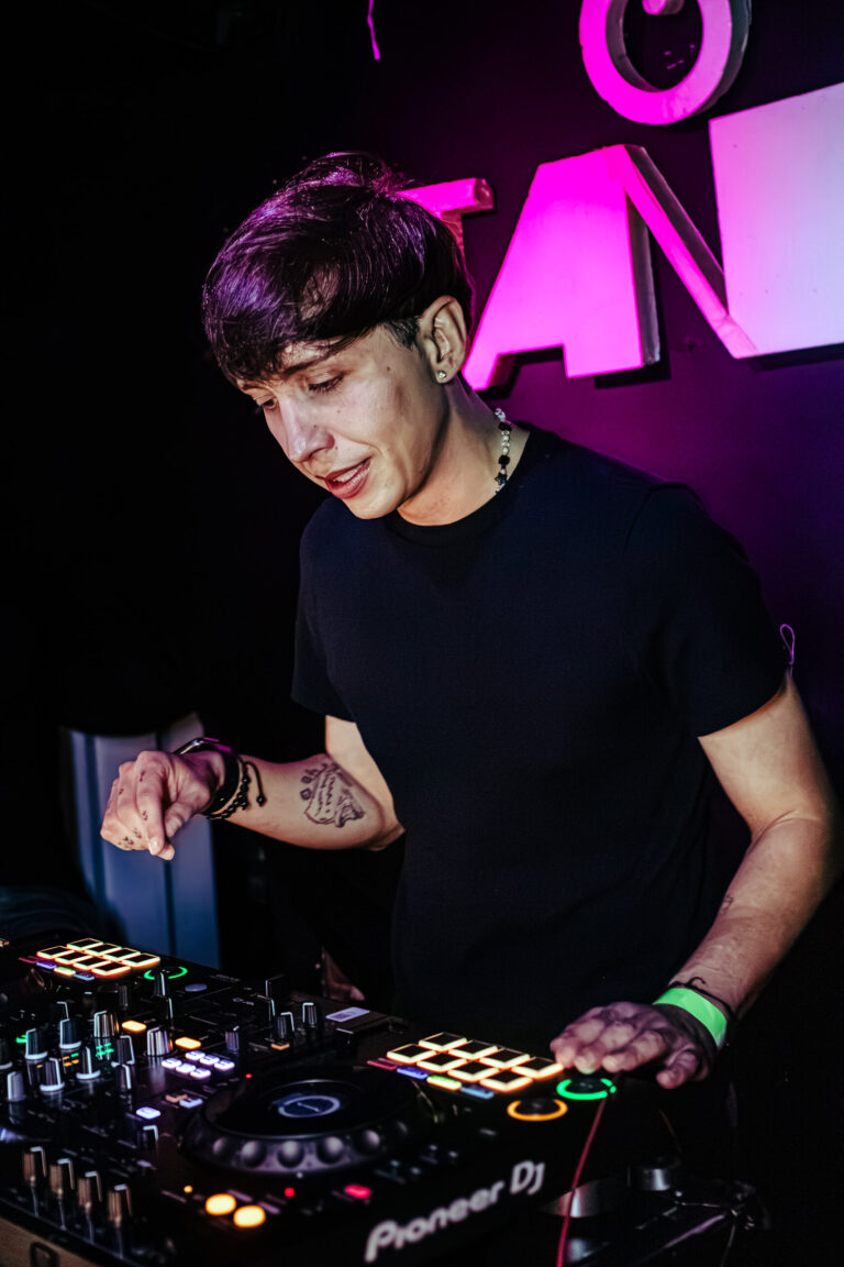 DJ concentrado no set sob luz rosa — Sad Baile Curitiba Halloween, 10/10/2026