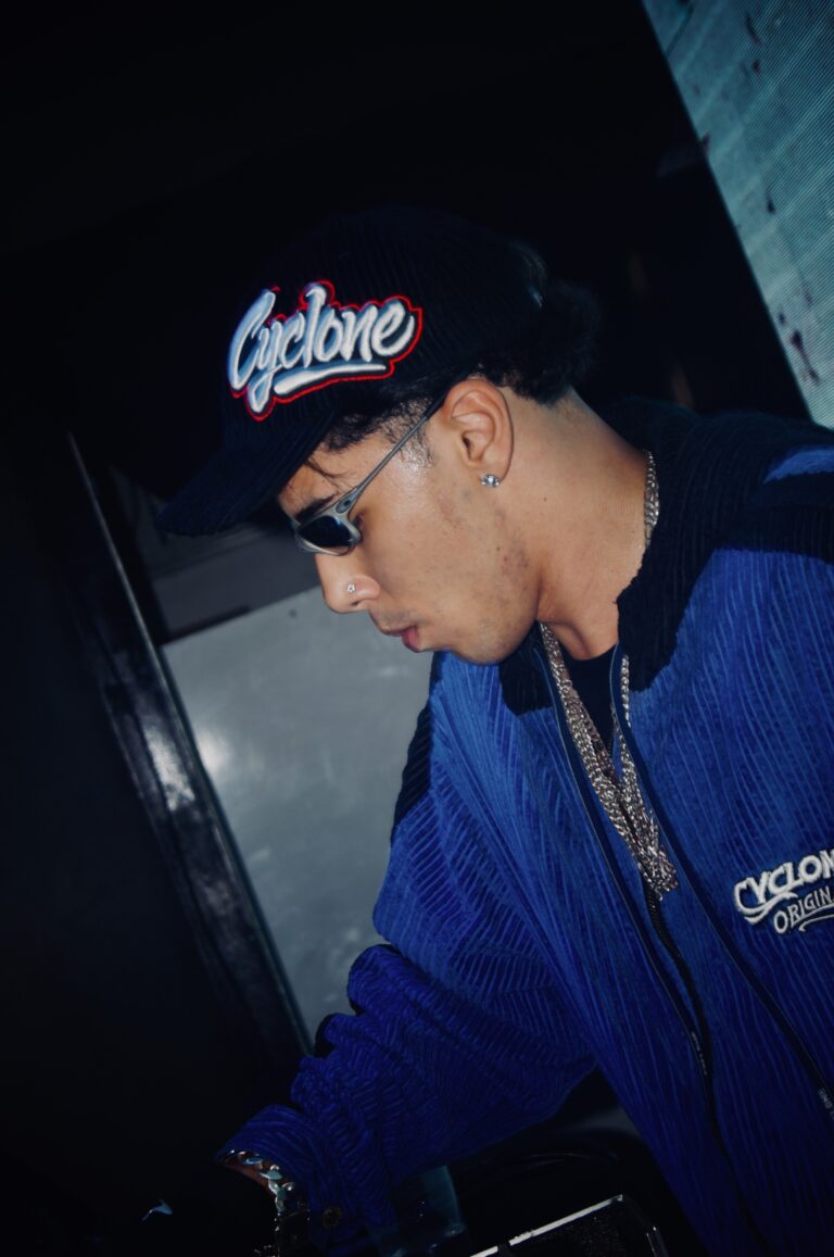 DJ de boné e óculos escuros com jaqueta azul — Sad Baile Joker, Halloween em São Paulo, 17/10/2026