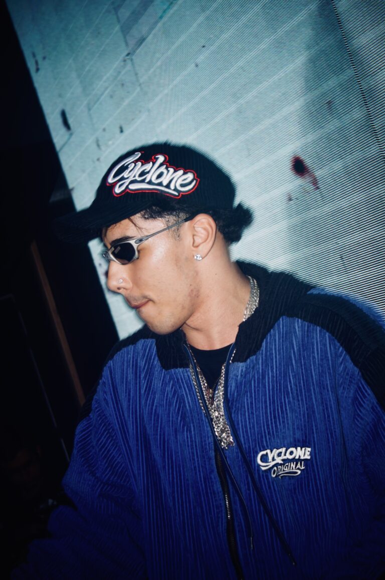DJ de boné e jaqueta azul olha para baixo — Sad Baile Joker, Halloween em São Paulo, 17/10/2026
