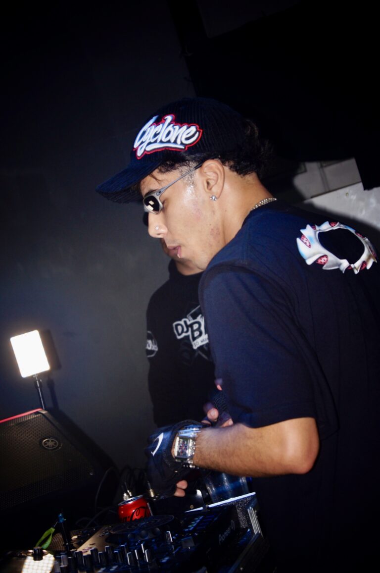DJ de boné e camiseta preta nos controles — Sad Baile Joker, Halloween em São Paulo, 17/10/2026