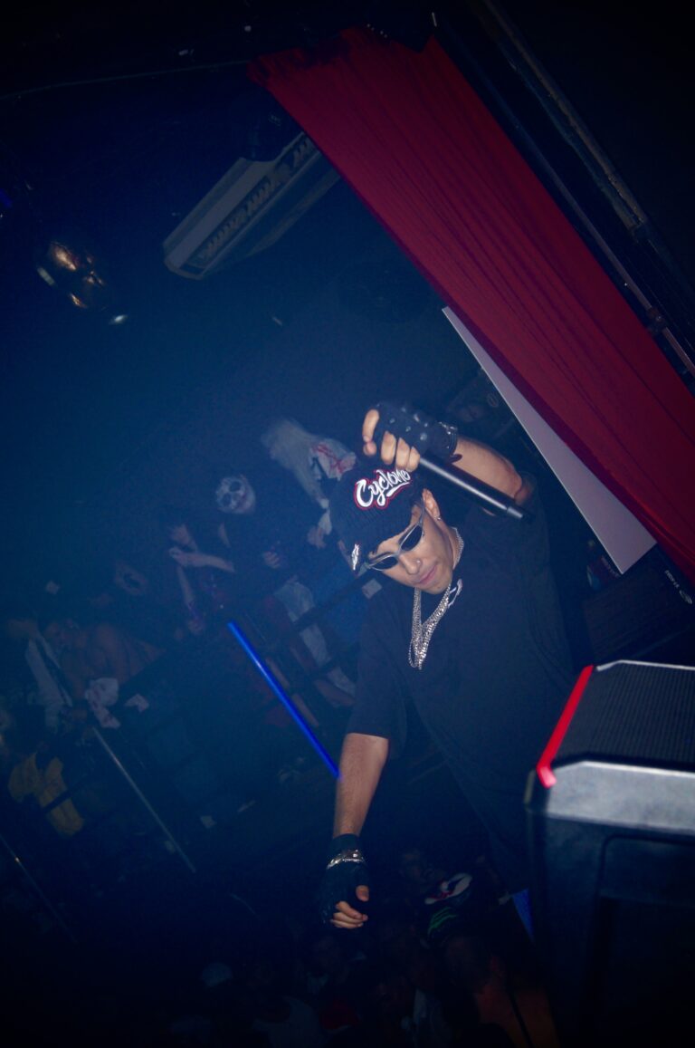 DJ de boné visto de cima sob luz azul — Sad Baile Joker, Halloween em São Paulo, 17/10/2026