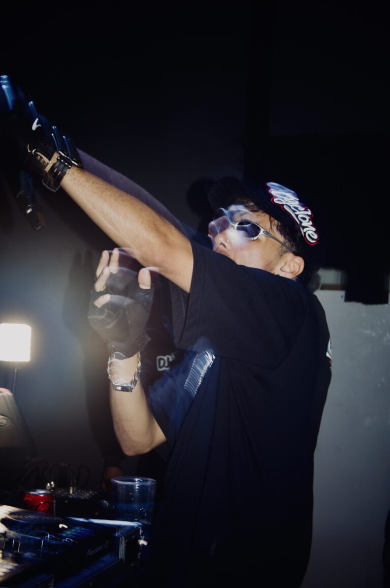 Rapper de óculos escuros ergue o braço na cabine — Sad Baile Joker, Halloween em São Paulo, 17/10/2026
