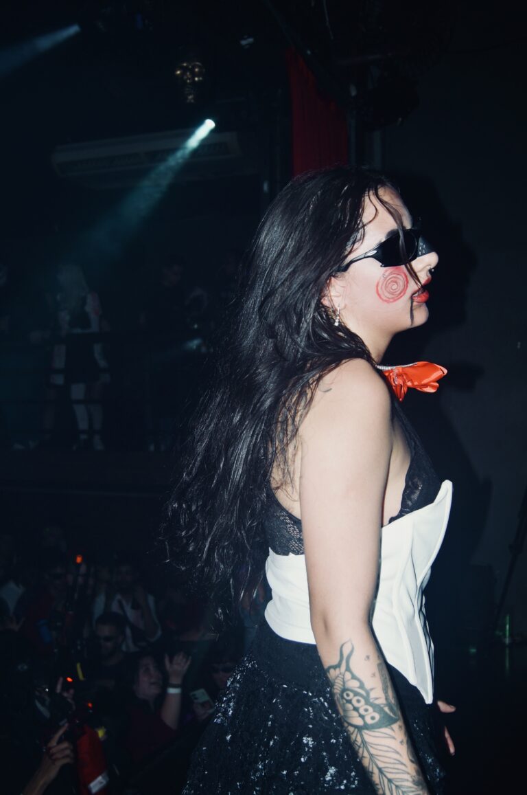 Garota de óculos escuros e cabelo comprido no palco — Sad Baile Joker, Halloween em São Paulo, 17/10/2026
