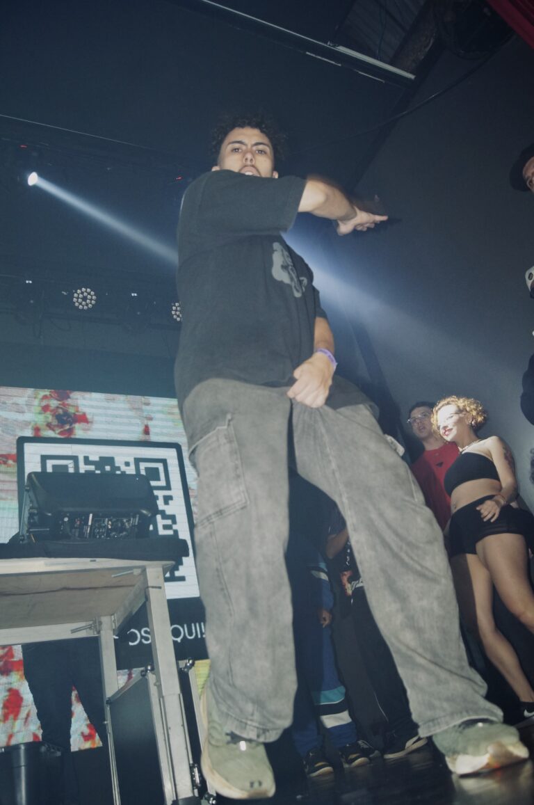 Artista de calça bege pisa na mesa do palco — Sad Baile Joker, Halloween em São Paulo, 17/10/2026