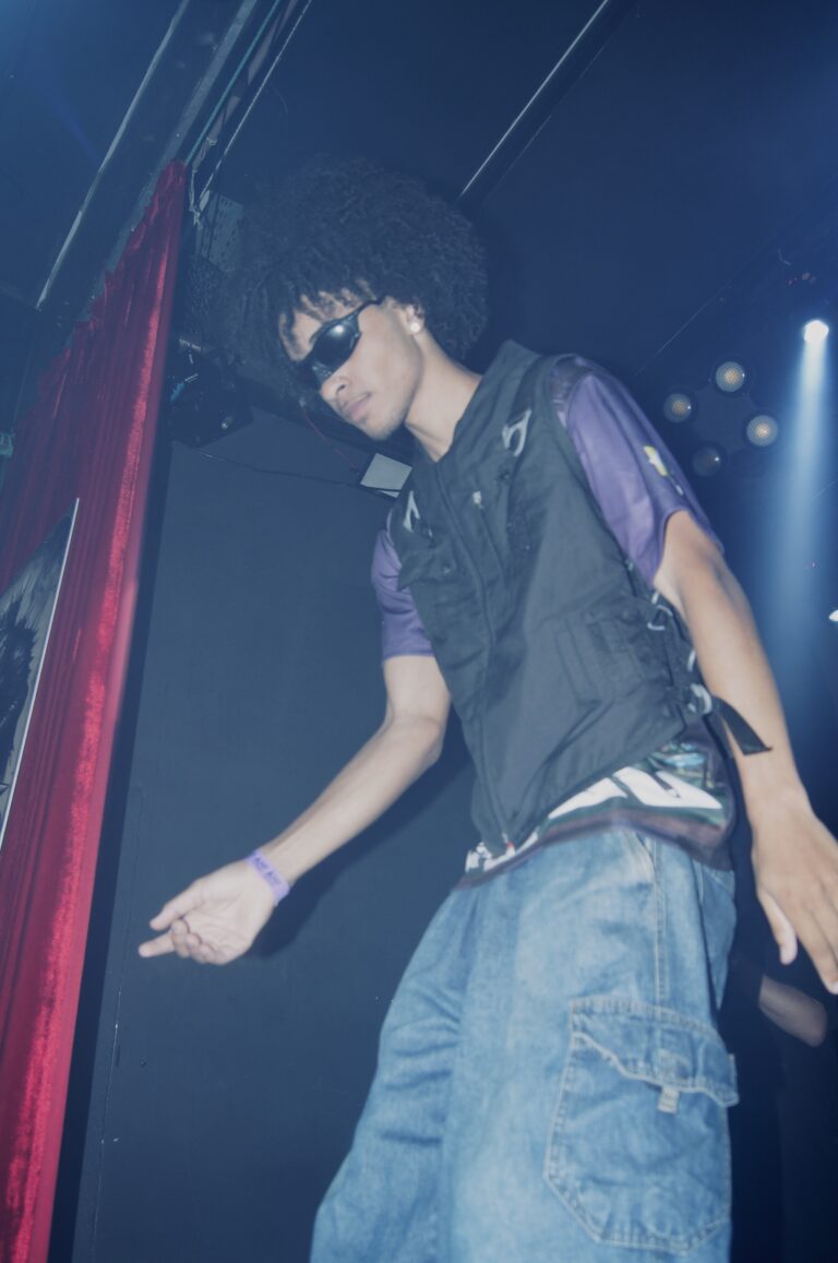Rapper de óculos escuros e cabelo black power no palco — Sad Baile Joker, Halloween em São Paulo, 17/10/2026