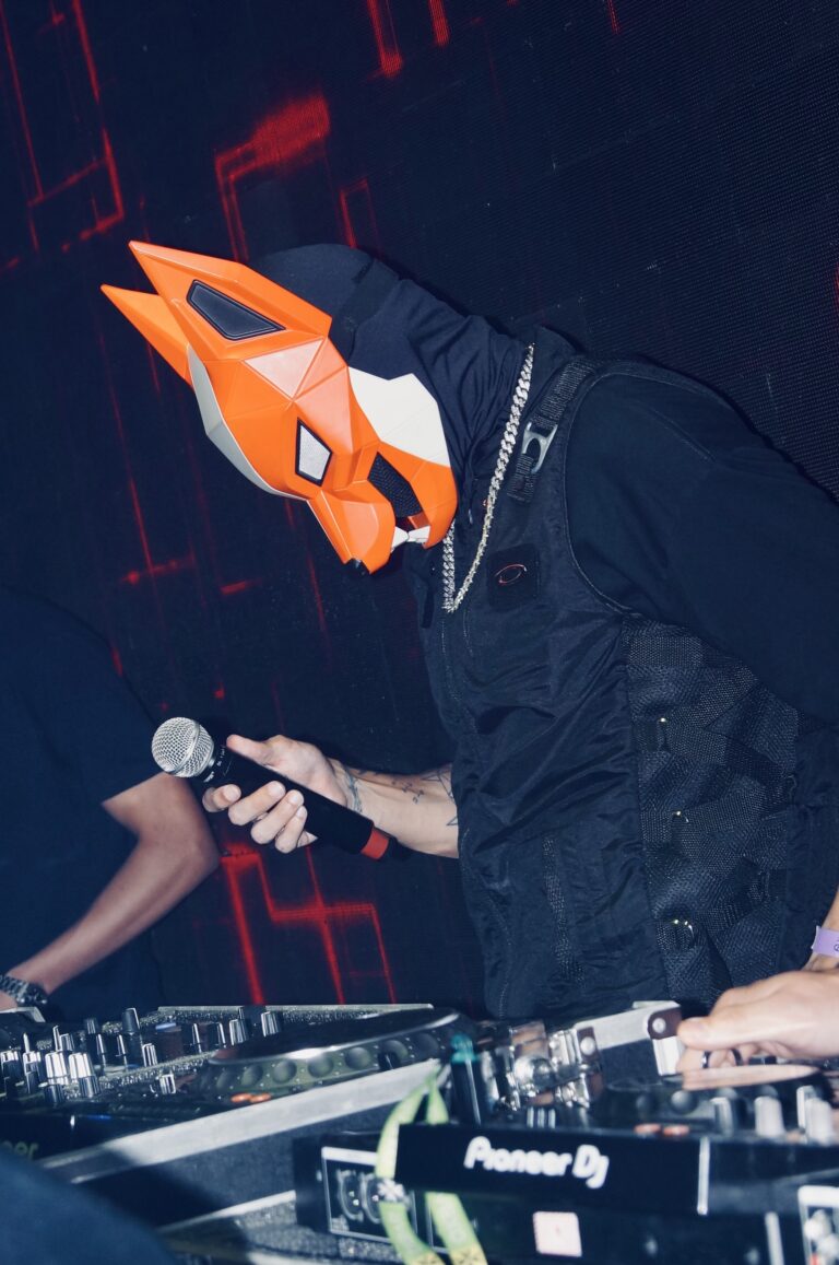 DJ mascarado canta ao microfone nos controles — Sad Baile Joker, Halloween em São Paulo, 17/10/2026