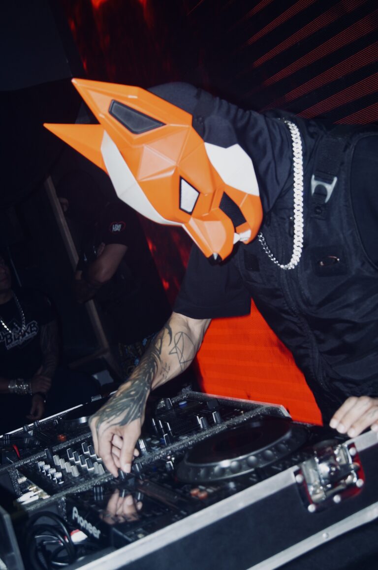 DJ de máscara de raposa toca com tatuagens nos braços — Sad Baile Joker, Halloween em São Paulo, 17/10/2026