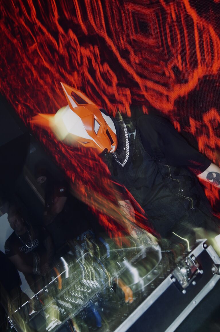 DJ mascarado em foto com efeito de luz vermelha — Sad Baile Joker, Halloween em São Paulo, 17/10/2026