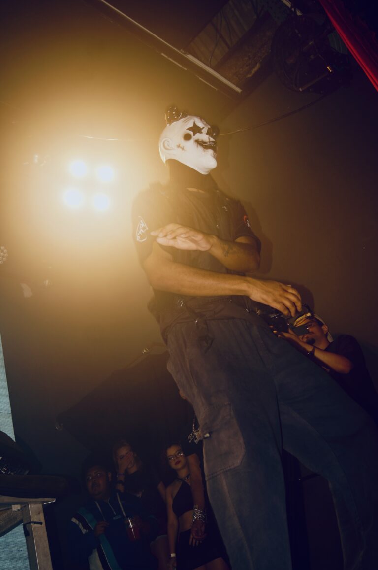 Artista de máscara de caveira sob luz amarela — Sad Baile Joker, Halloween em São Paulo, 17/10/2026