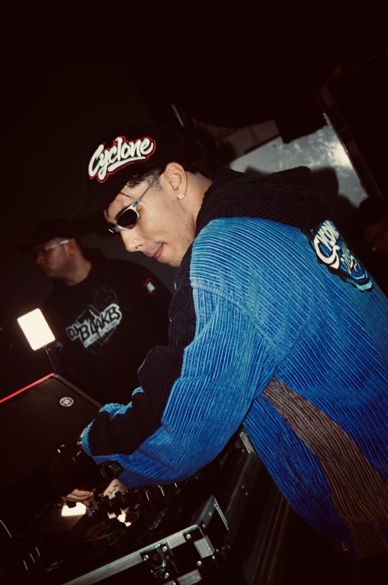 DJ de boné e jaqueta azul olha para a câmera — Sad Baile Joker, Halloween em São Paulo, 17/10/2026