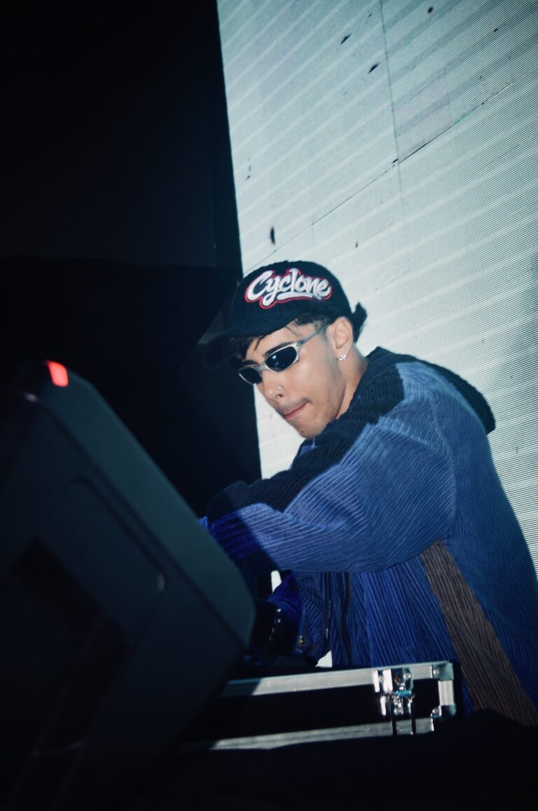 DJ de óculos escuros sorri nos controles — Sad Baile Joker, Halloween em São Paulo, 17/10/2026