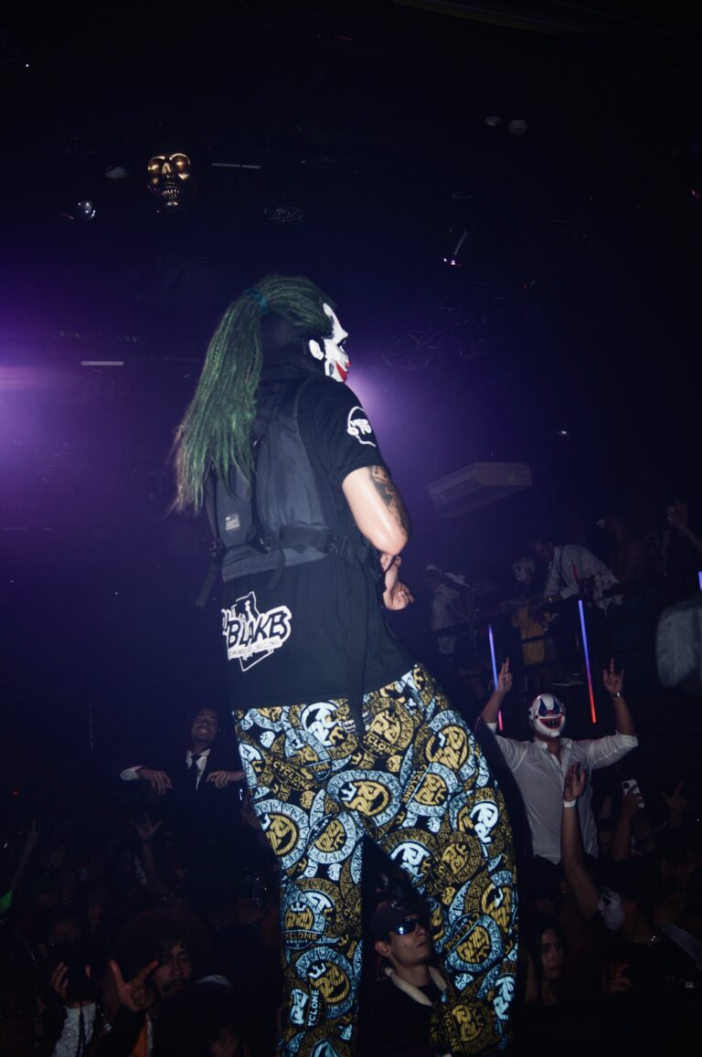 Artista de peruca verde sob luz roxa — Sad Baile Joker, Halloween em São Paulo, 17/10/2026