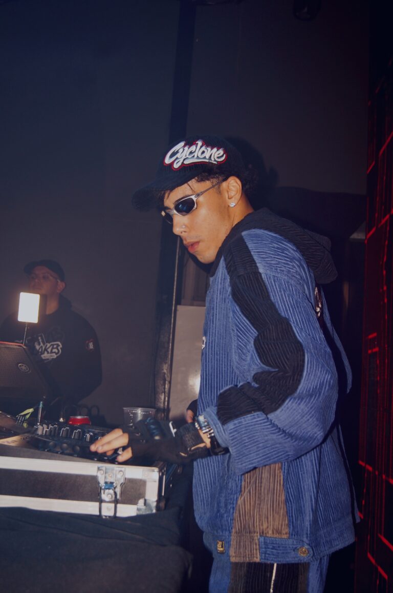 DJ de boné e jaqueta azul nos controles — Sad Baile Joker, Halloween em São Paulo, 17/10/2026