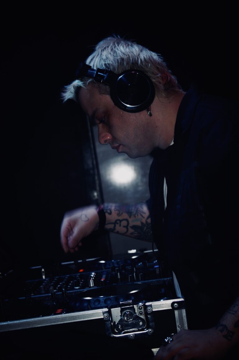 DJ de fones mixando sob luz branca — Sad Baile Joker, Halloween em São Paulo, 17/10/2026