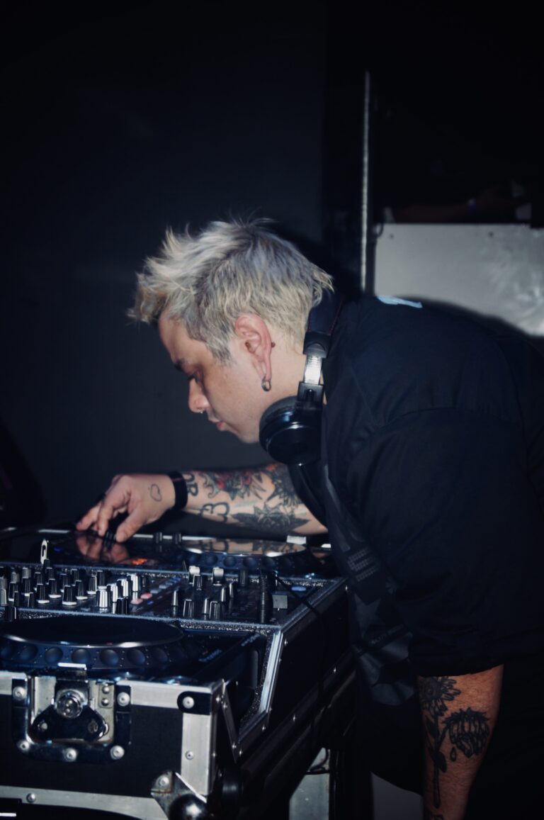 DJ de fones inclinado sobre o mixer — Sad Baile Joker, Halloween em São Paulo, 17/10/2026