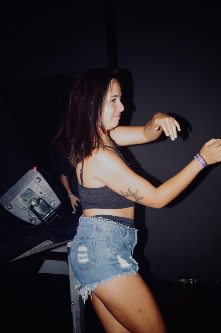 Garota de top e shorts jeans dança sorrindo — Sad Baile Joker, Halloween em São Paulo, 17/10/2026