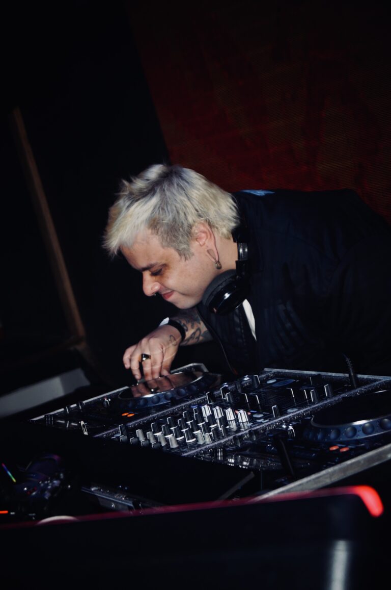 DJ de fones mexe nos controles sob luz vermelha — Sad Baile Joker, Halloween em São Paulo, 17/10/2026
