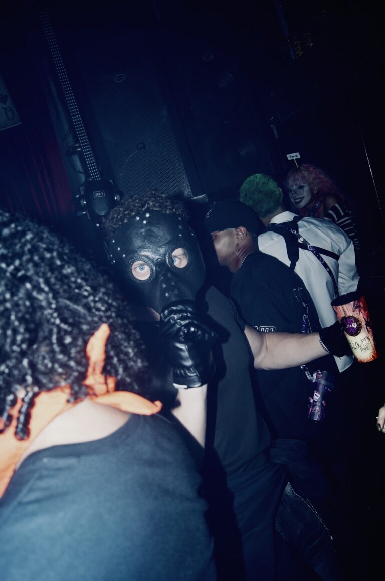 Pessoa de máscara de gás e capuz na pista — Sad Baile Joker, Halloween em São Paulo, 17/10/2026