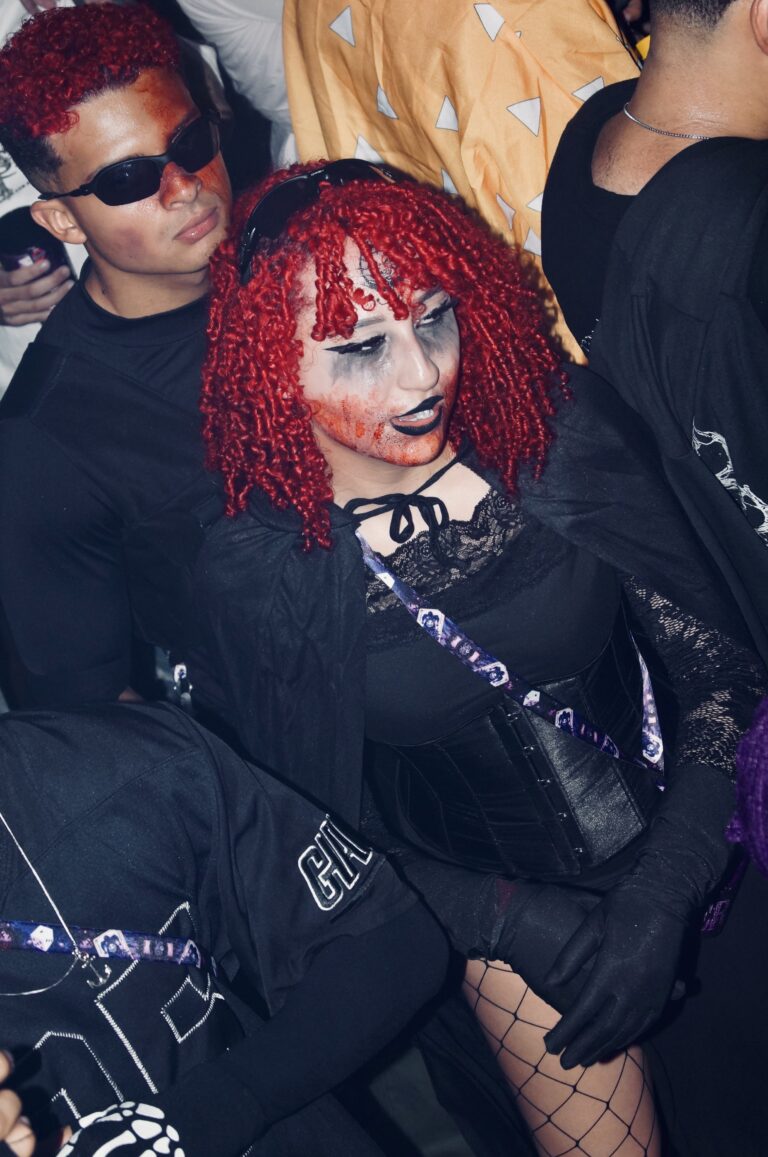 Garota de peruca ruiva cacheada e amigo de óculos escuros — Sad Baile Joker, Halloween em São Paulo, 17/10/2026