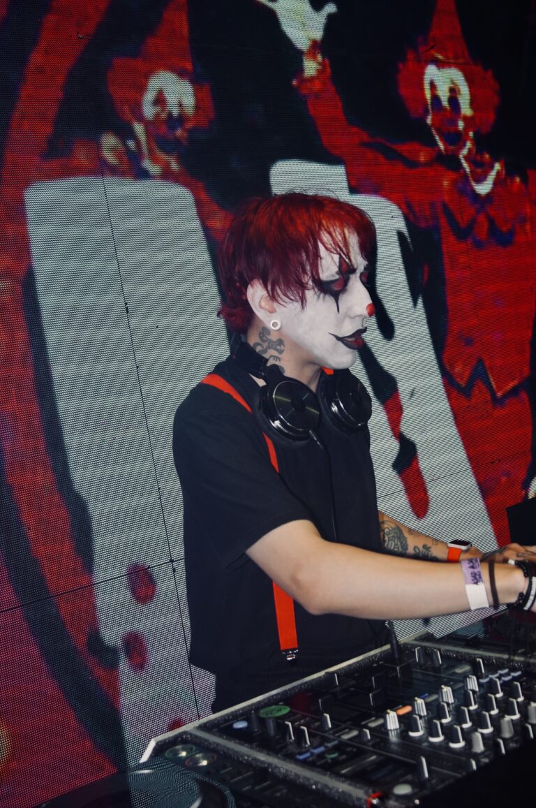 DJ com maquiagem de palhaço diante do telão de palhaços — Sad Baile Joker, Halloween em São Paulo, 17/10/2026