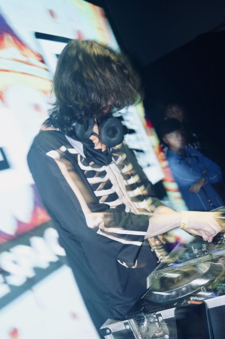 DJ de jaqueta de esqueleto diante do telão claro — Sad Baile Joker, Halloween em São Paulo, 17/10/2026