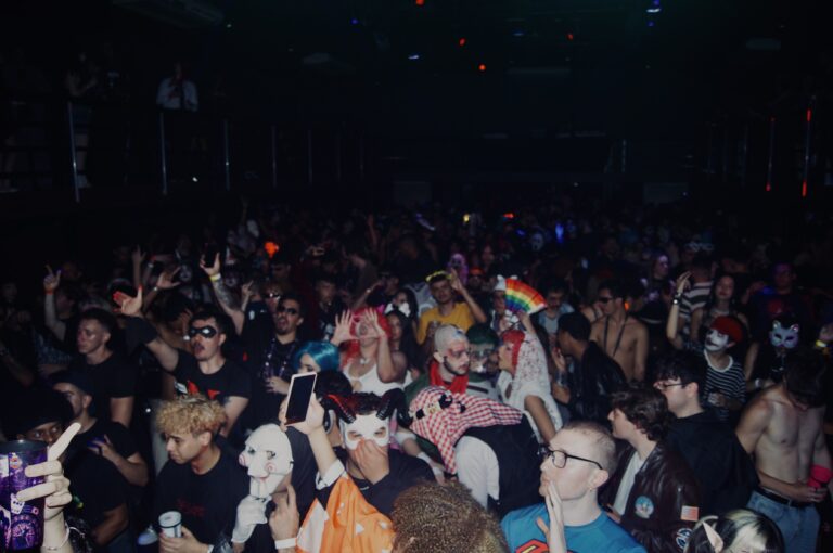 Pista lotada de fantasias sob luz baixa — Sad Baile Joker, Halloween em São Paulo, 17/10/2026