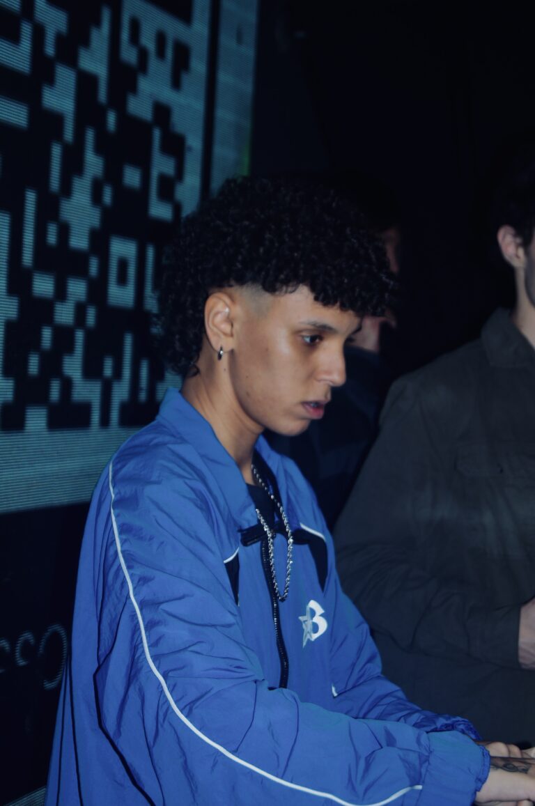 DJ de jaqueta azul e cabelo cacheado — Sad Baile Joker, Halloween em São Paulo, 17/10/2026