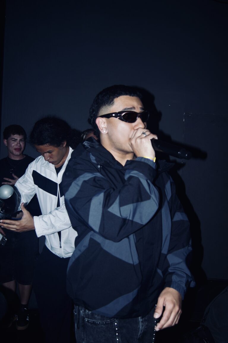 Rapper de óculos escuros canta ao microfone — Sad Baile Joker, Halloween em São Paulo, 17/10/2026