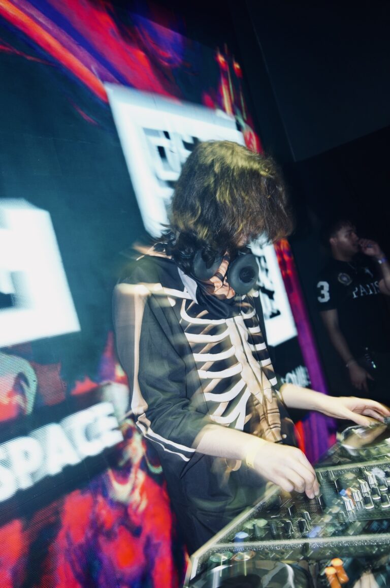 DJ de jaqueta de esqueleto diante do QR code no telão — Sad Baile Joker, Halloween em São Paulo, 17/10/2026