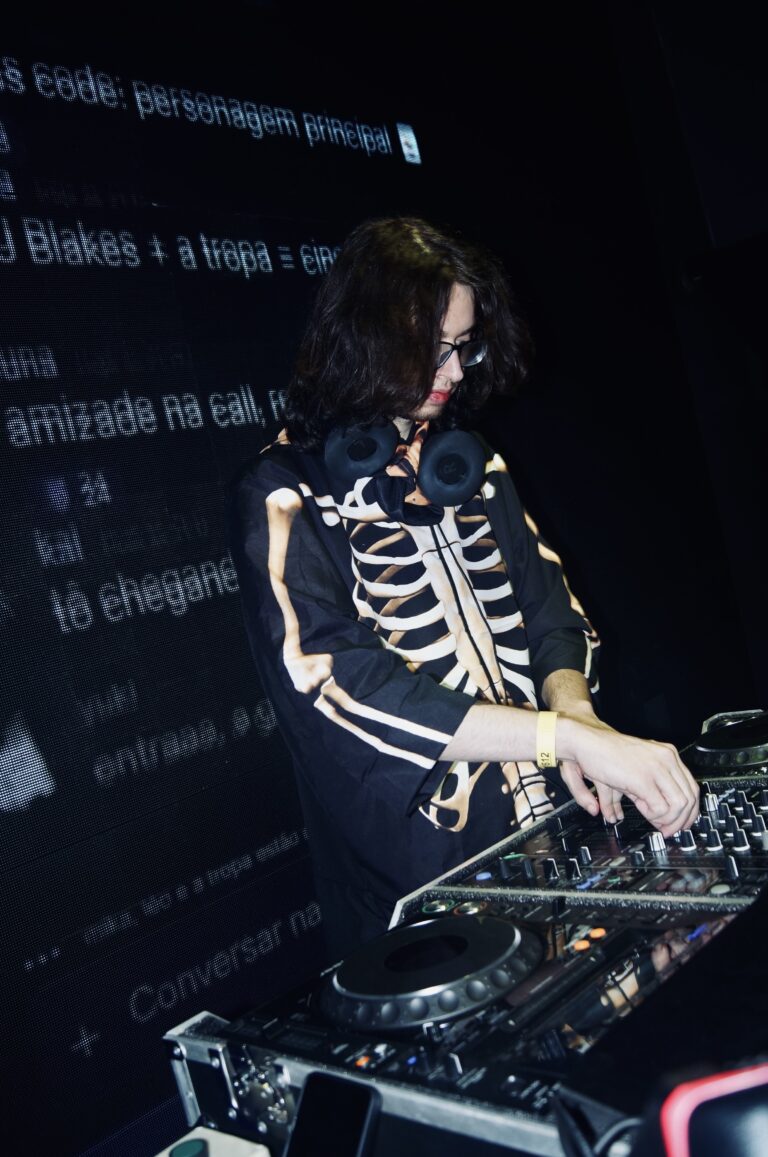 DJ de jaqueta de ossos nos controles — Sad Baile Joker, Halloween em São Paulo, 17/10/2026