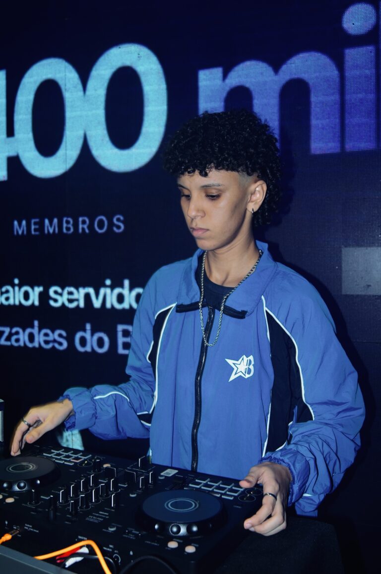 DJ de jaqueta azul diante do telão com texto — Sad Baile Joker, Halloween em São Paulo, 17/10/2026