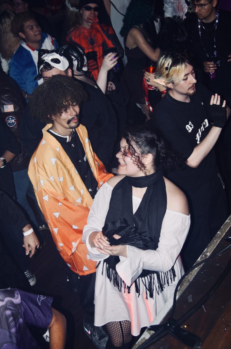 Rapaz de kimono laranja e garota de branco dançam — Sad Baile Joker, Halloween em São Paulo, 17/10/2026