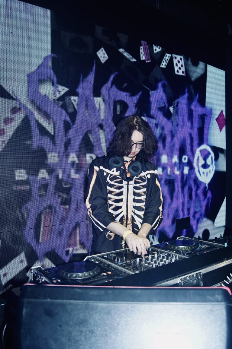 DJ de jaqueta de esqueleto diante do logo roxo da Sad Baile — Sad Baile Joker, Halloween em São Paulo, 17/10/2026