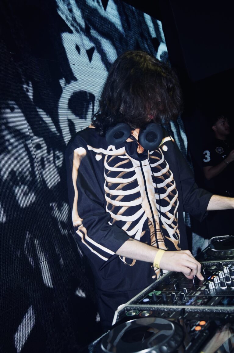 DJ de jaqueta de esqueleto com o telão preto e branco — Sad Baile Joker, Halloween em São Paulo, 17/10/2026